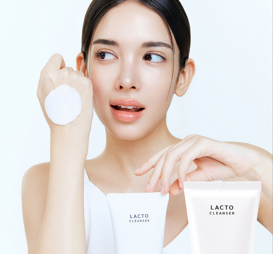 Woman holding LACTO CLEANSER packaging with a white background